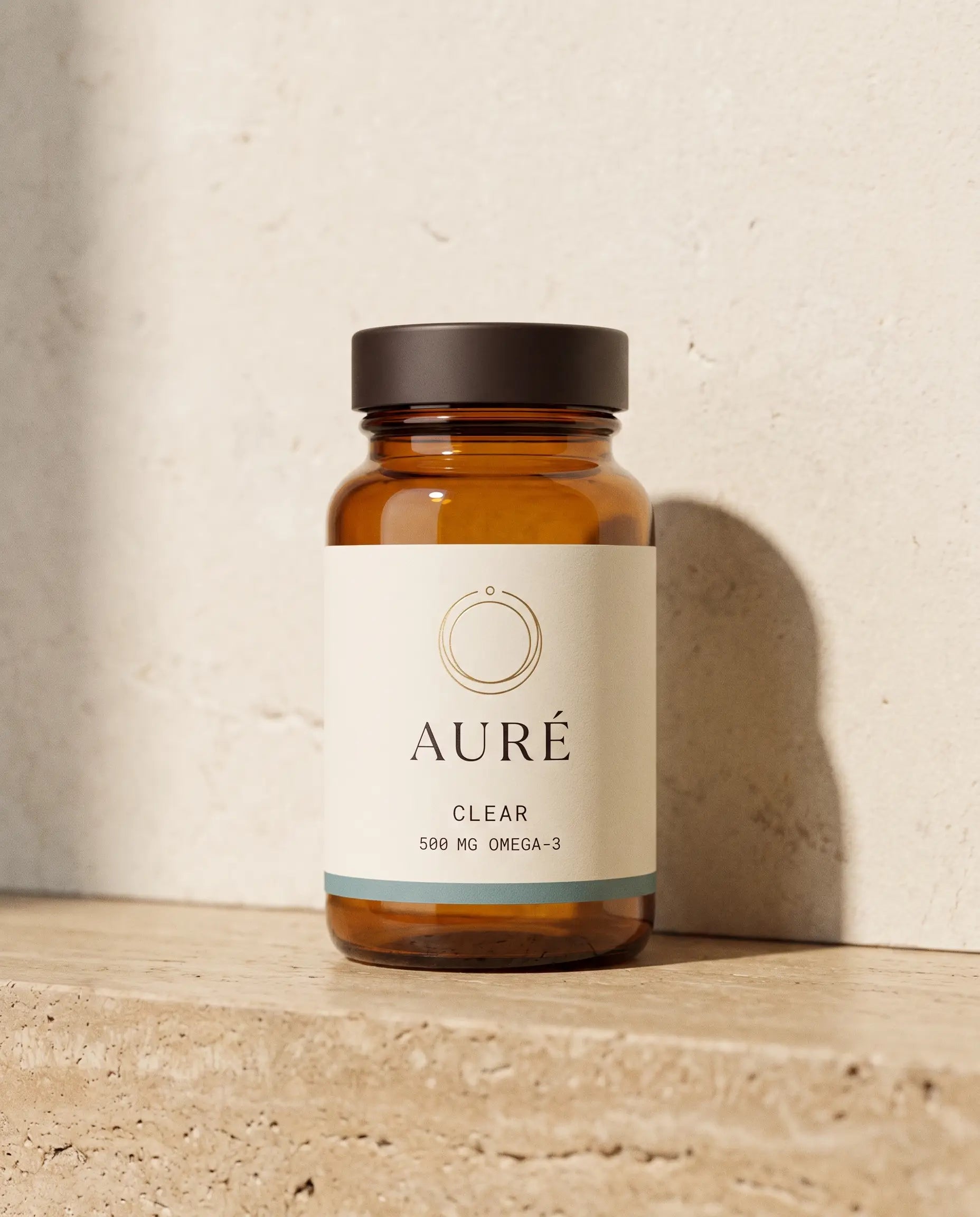AURÉ Clear — honey-amber glass bottle, cream label printed with 500 mg omega-3