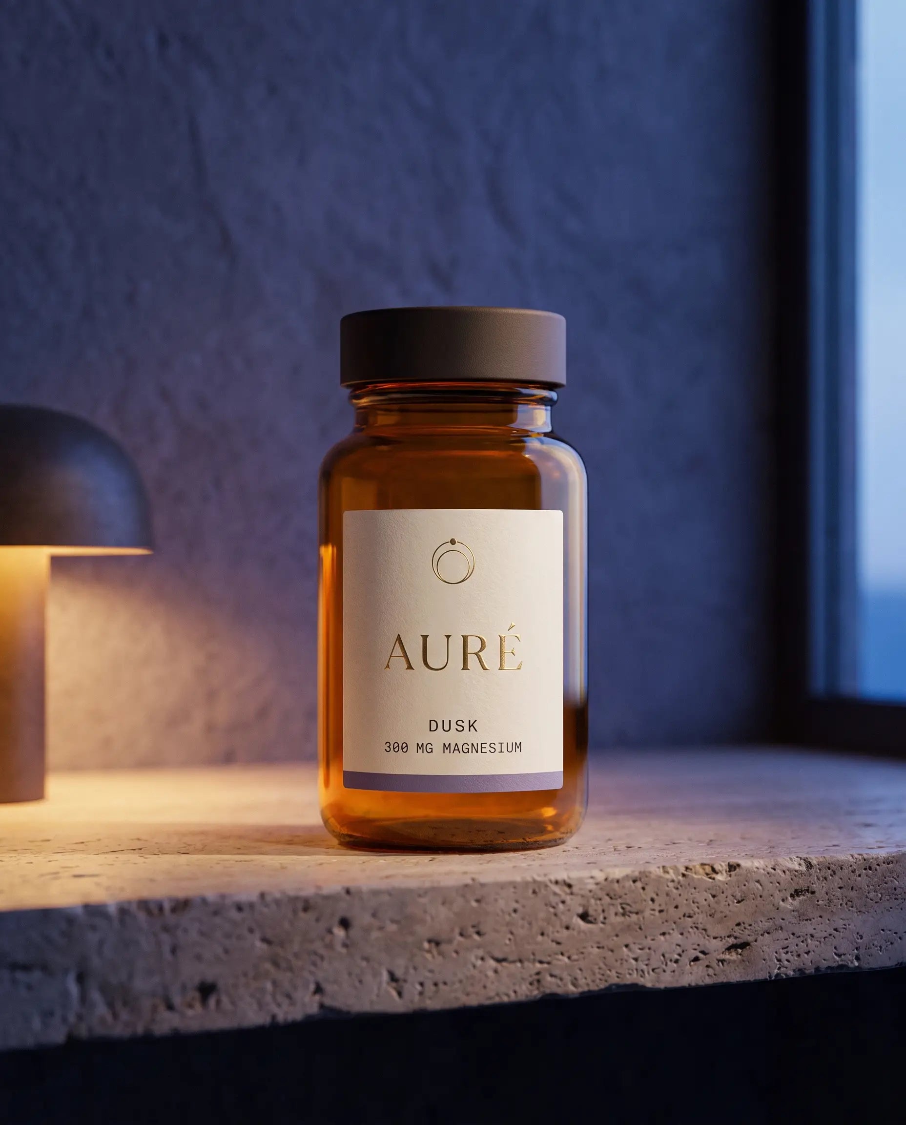 AURÉ Dusk — honey-amber glass bottle, cream label printed with 300 mg magnesium