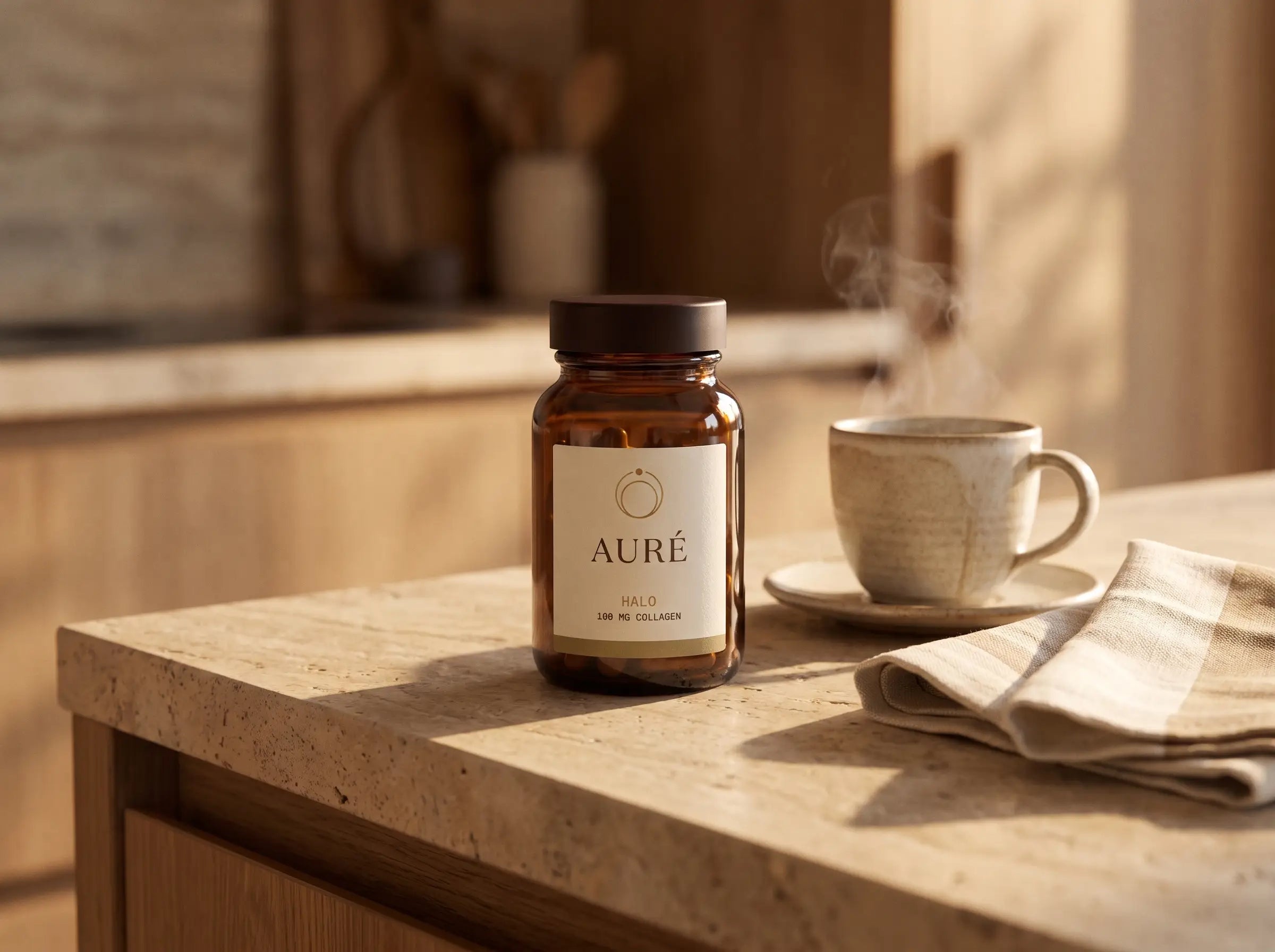 Morning kitchen counter in first light — the AURÉ Halo bottle beside a steaming coffee cup